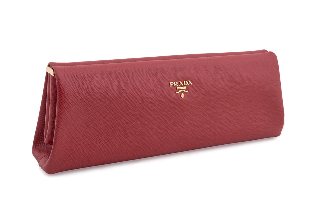 PRADA RED SAFFIANO LEATHER LUX EAST WEST CLUTCH: Prada (Italian, founded 1913). Red saffiano leather lux clutch with gold toned hardware. Frame snap lock closure with release button on right side. Accompanied by dust bag, box, and authenticity card.