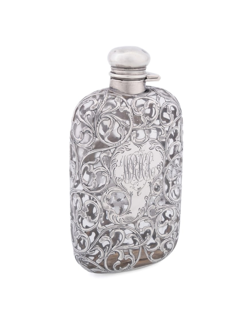 AMERICAN STERLING SILVER OVER GLASS FLASK: Likely American, late 19th to early 20th century. Sterling silver over colorless glass flask, having reticulated foliate overlay enclosing a cartouche, appropriately marked. Provenance: Private Collec
