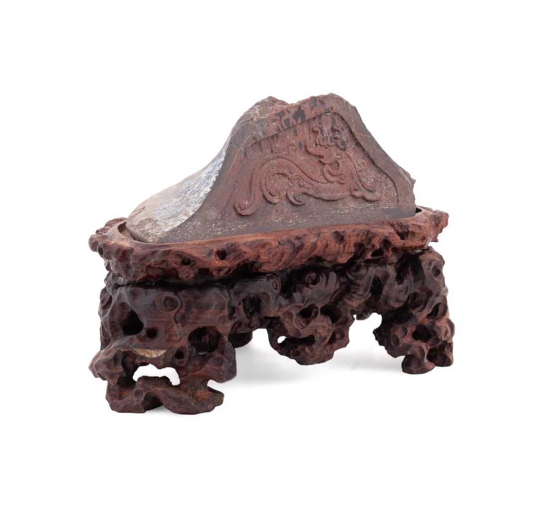 CHINESE ARCHAIC STYLE DRAGON MARBLE CARVING: Chinese. Red marble fragment, having an archaic style carving of a dragon, apparently unmarked.,on wooden stand. Provenance: The Estate of Jain Ming James Wu, Huntsville, AL. Approximate dimensions: o