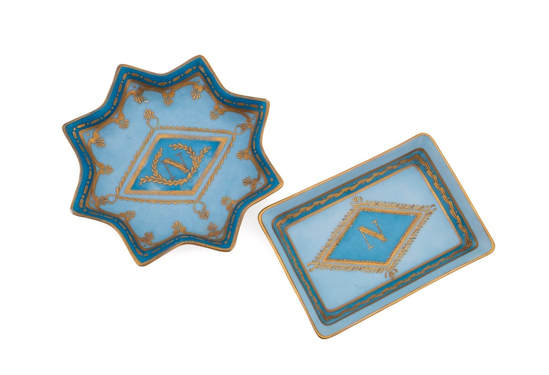 PARIS DE PORCELAIN, TWO NAPOLEONIC TRINKET TRAYS: Porcelain de Paris (French, founded 1773), 20th century. Set of two gilded blue two-tone Napoleonic porcelain trinket trays, one rectangular and one star-form, each having a "N" monogram, and each app