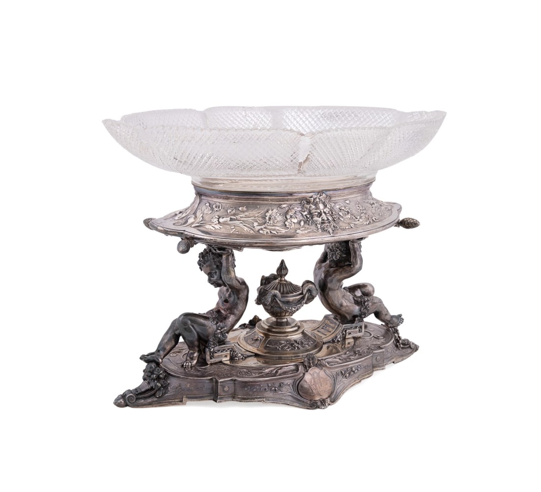 ELKINGTON & CO. STERLING AND CUT GLASS CENTERPIECE: Marks of Elkington & Co. / Frederick Elkington (English (Birmingham), 1830s-1963), 1880. Victorian armorial Louis XVI Revival sterling silver figural centerpiece, having a colorless cut glass bowl sup