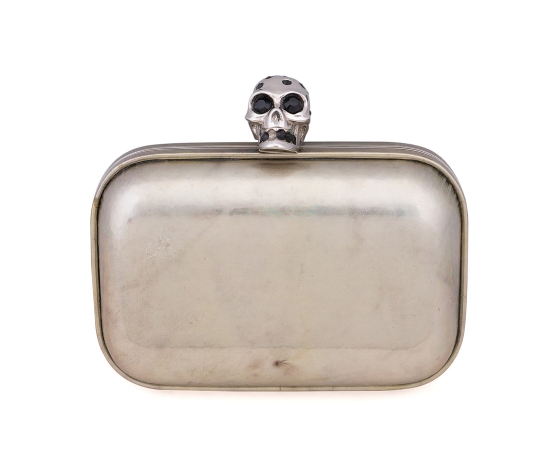 ALEXANDER MCQUEEN CHAMPAGNE SKULL BOX CLUTCH: Alexander McQueen (British, founded 1992). Metallic champagne leather skull box clutch with silver toned hardware, brown suede lining, and skull snap closure. Maker's mark and serial number to interio