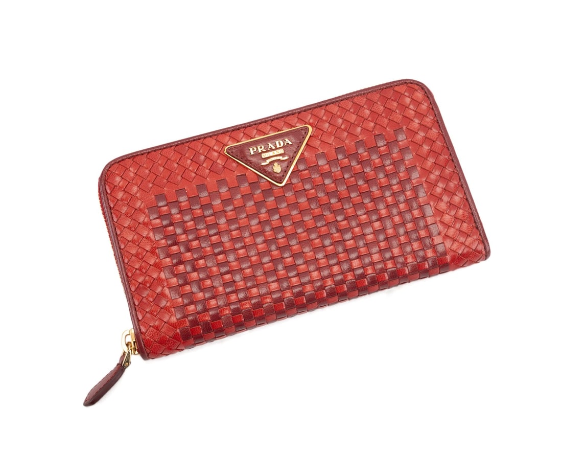 PRADA TWO TONE RED LEATHER WOVEN ZIP WALLET: Prada (Italian, founded 1913), "Made in India" 2010 collection. Two tone red leather woven continental zip wallet with gold toned hardware. Appropriate maker's marks, "Made in India" to interior leath