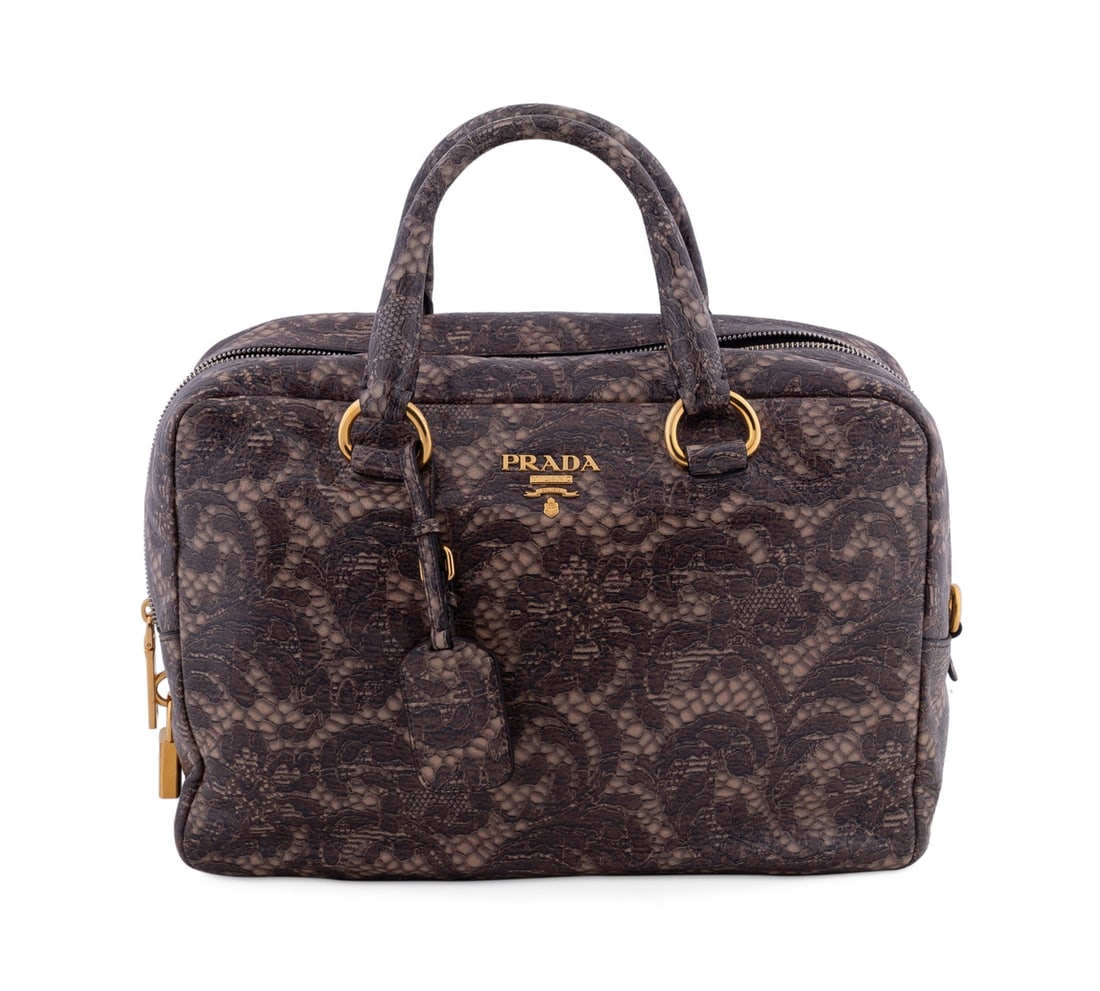 PRADA LACE PRINT CERVO LEATHER BOWLER BAG: Prada (Italian, founded 1913). Brown and tan lace print cervo leather bowler bag with gold toned hardware, two top handles, double track top zipper, and leather interior lining. Accompanied by dust ba