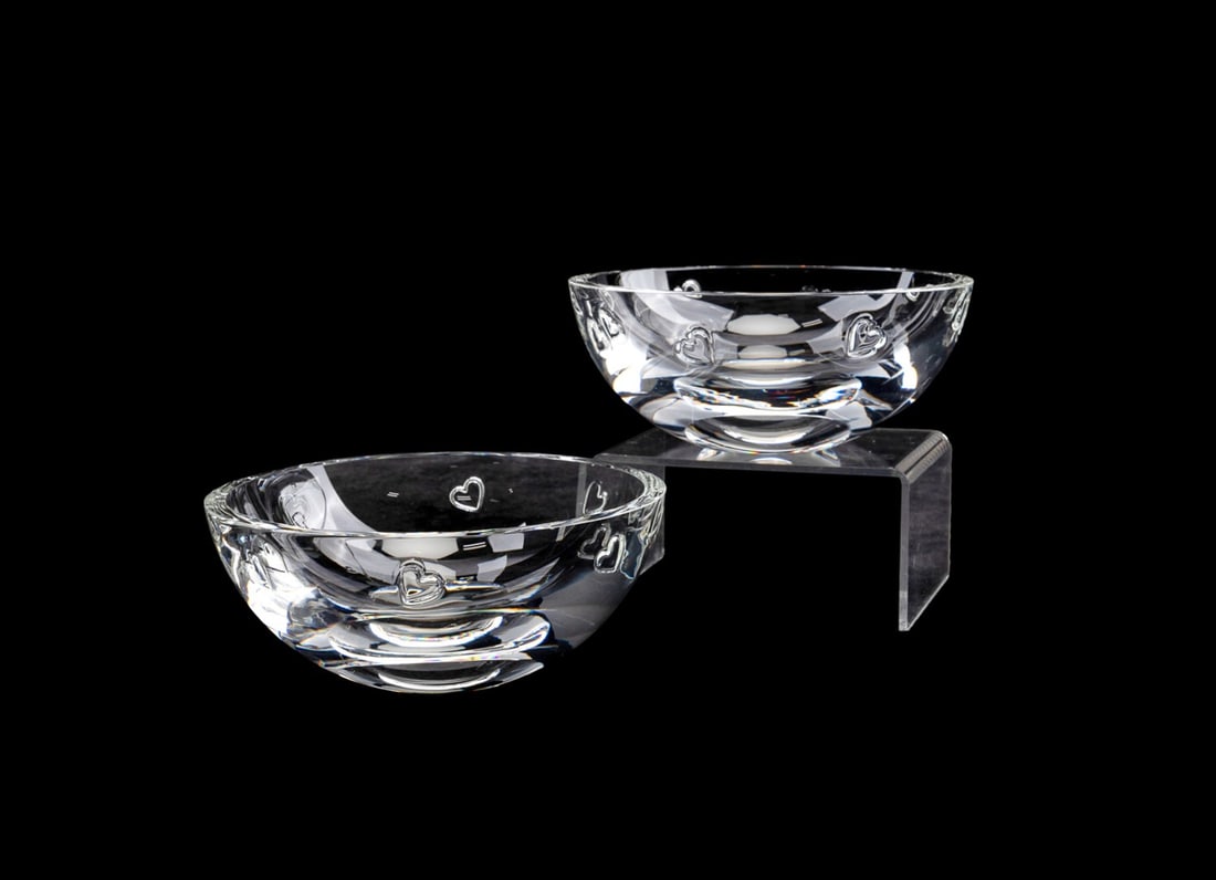 STEUBEN, PAIR OF HEART MOTIF BOWLS: Steuben (American, founded 1903), late 20th to early 21st century. Pair of colorless crystal bowls, each having a band of hearts, both appropriately marked . Approximate measurements: h. 2", dia. 5.5"