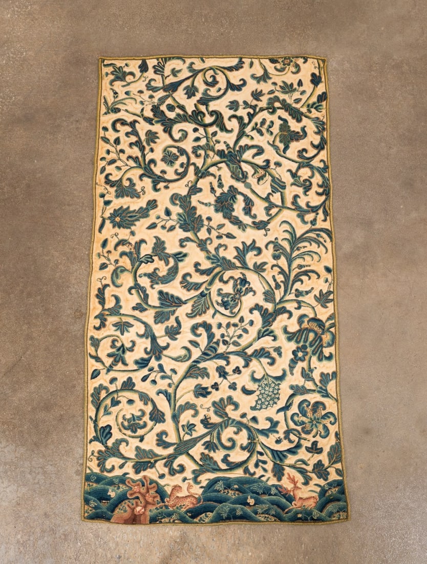 17TH/18TH C. ENGLISH WOOL CREWELWORK TEXTILE PANEL: English, late 17th / early 18th century. Crewelwork panel, having colored wool on linen ground, depicting scrolling vines and stylized flowers above rounded hills featuring a stag, leopard and rabbits