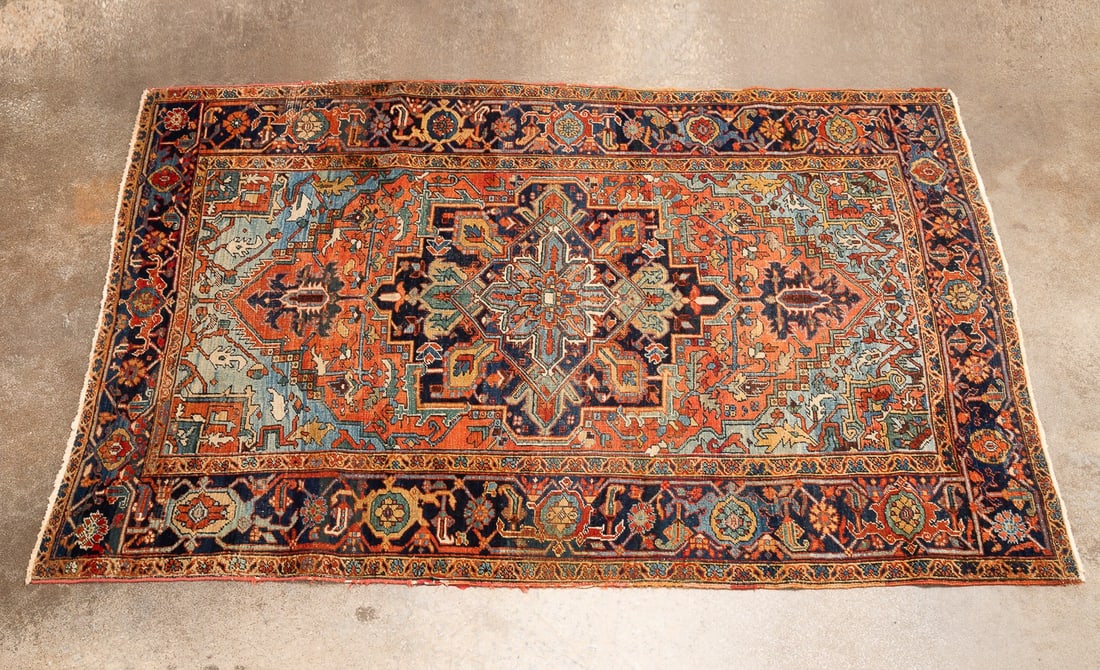 HAND-WOVEN PERSIAN HERIZ RUG: Persian, 20th century. Hand-woven Heriz rug decorated in red, blue and bone, apparently unsigned. Approximate dimensions: l. 9' 4", w. 6' 4".