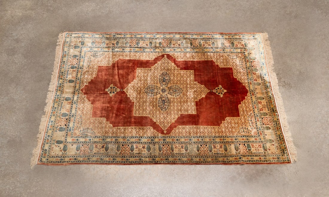 HAND-WOVEN TURKISH HEREKE SILK RUG: Turkish, 20th century. Hand-woven silk Hereke rug decorated in tones of red, tan, and bone, apparently unsigned. Approximate dimensions: l. 8' 2", w. 5' 9".