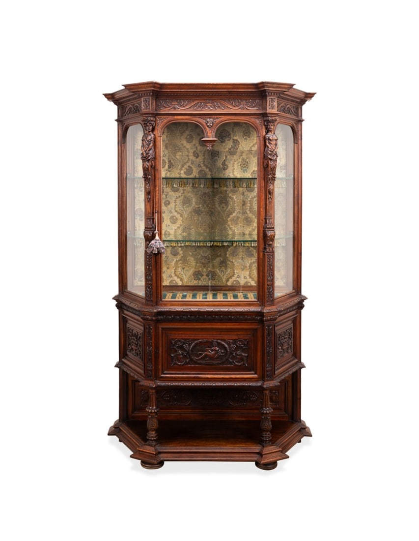 FRENCH RENAISSANCE REVIVAL WALNUT CABINET: French. Renaissance revival walnut cabinet with glass door and canted glass sides, figural pilasters of a male and female, the base having a cupboard with highly curved door of scrolling vines, fruit,