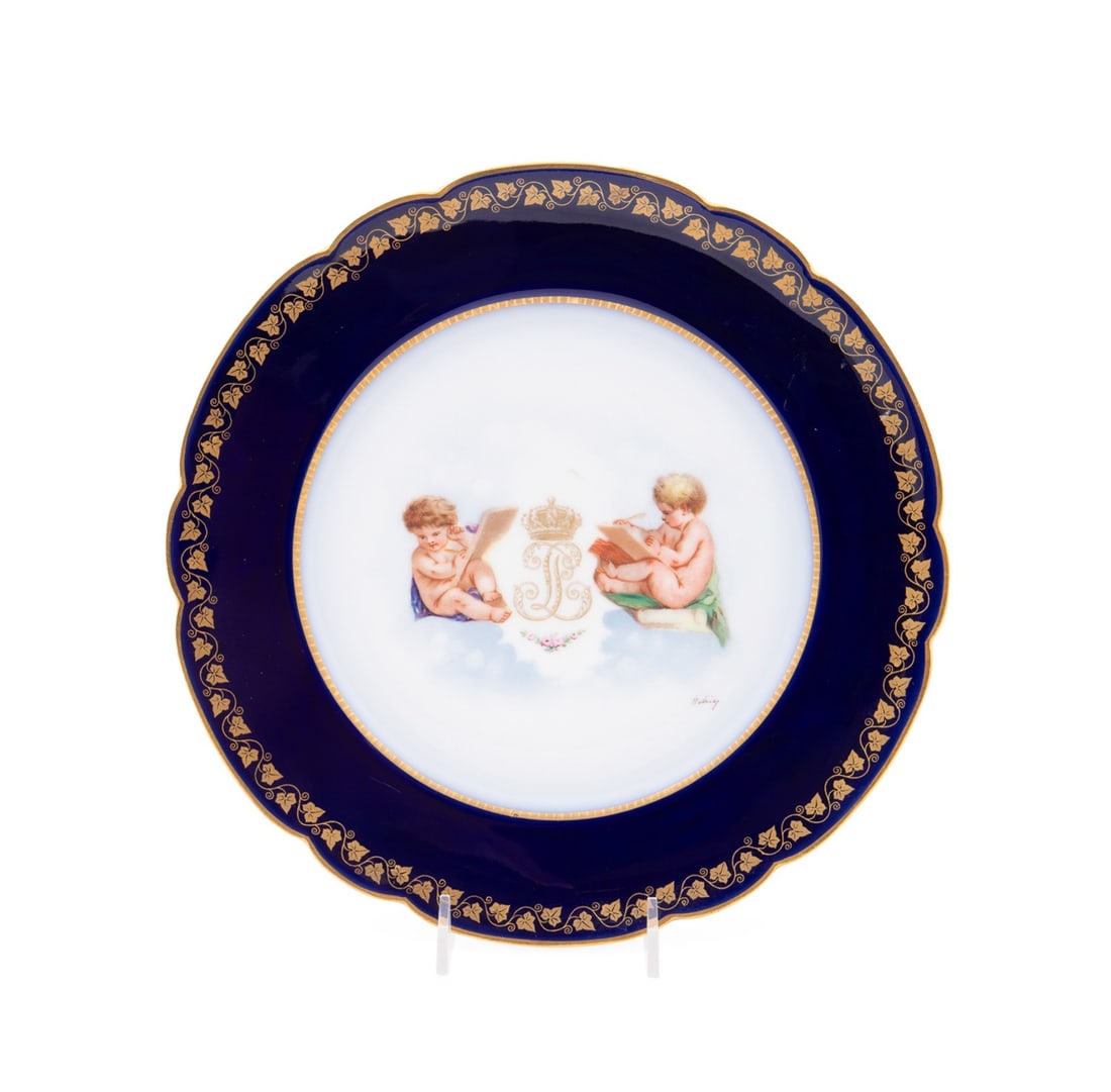 SEVRES STYLE LOUIS PHILIPPE CABINET PLATE: Manner Sevres Manufactory (French, founded 1740), late 19th to early 20th century. Gilded cobalt ground cabinet plate, having the crowned monogram or cypher for Louis Philippe flanked by putti, signed