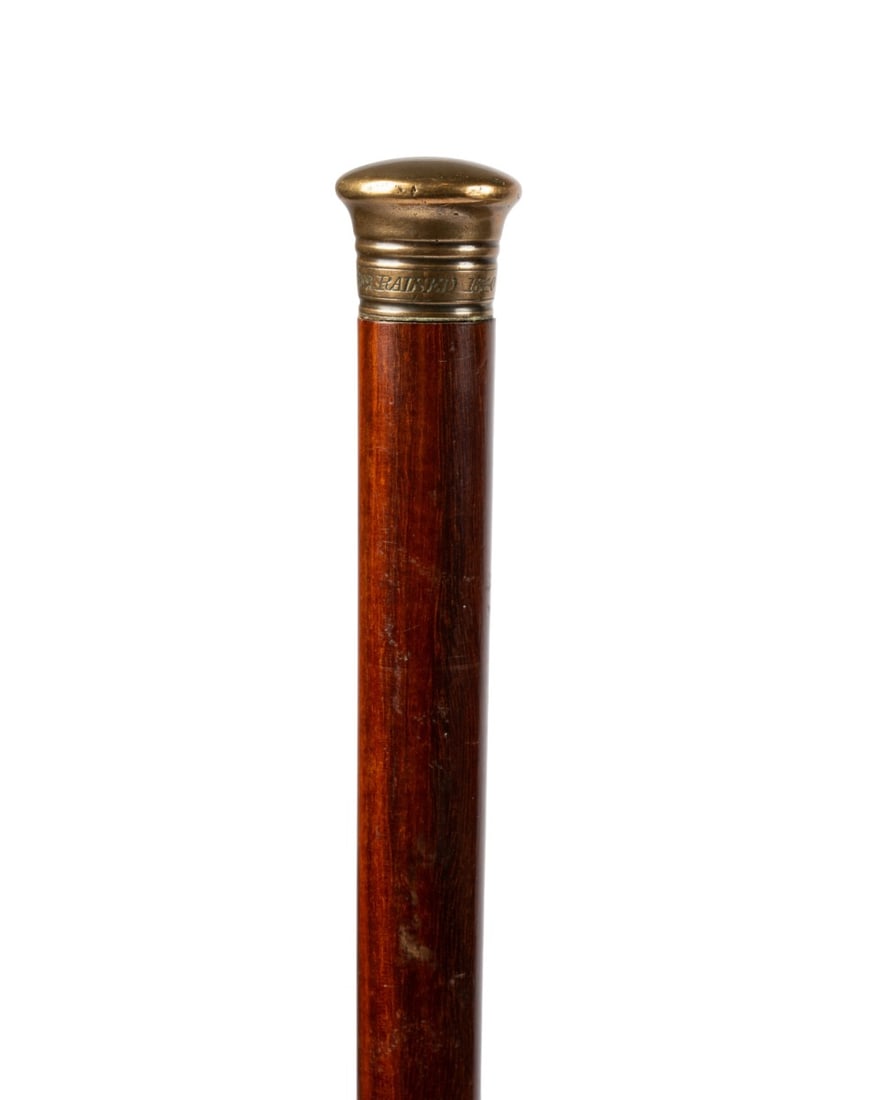 HMS ROYAL GEORGE SHIPWRECK TIMBER CANE: English, circa 1782-1840. Walking cane with oak shaft and metal knob handle engraved "Royal George Sunk 1782 - Raised 1840," made from timber salvaged from the shipwreck HMS Royal George, and a brass