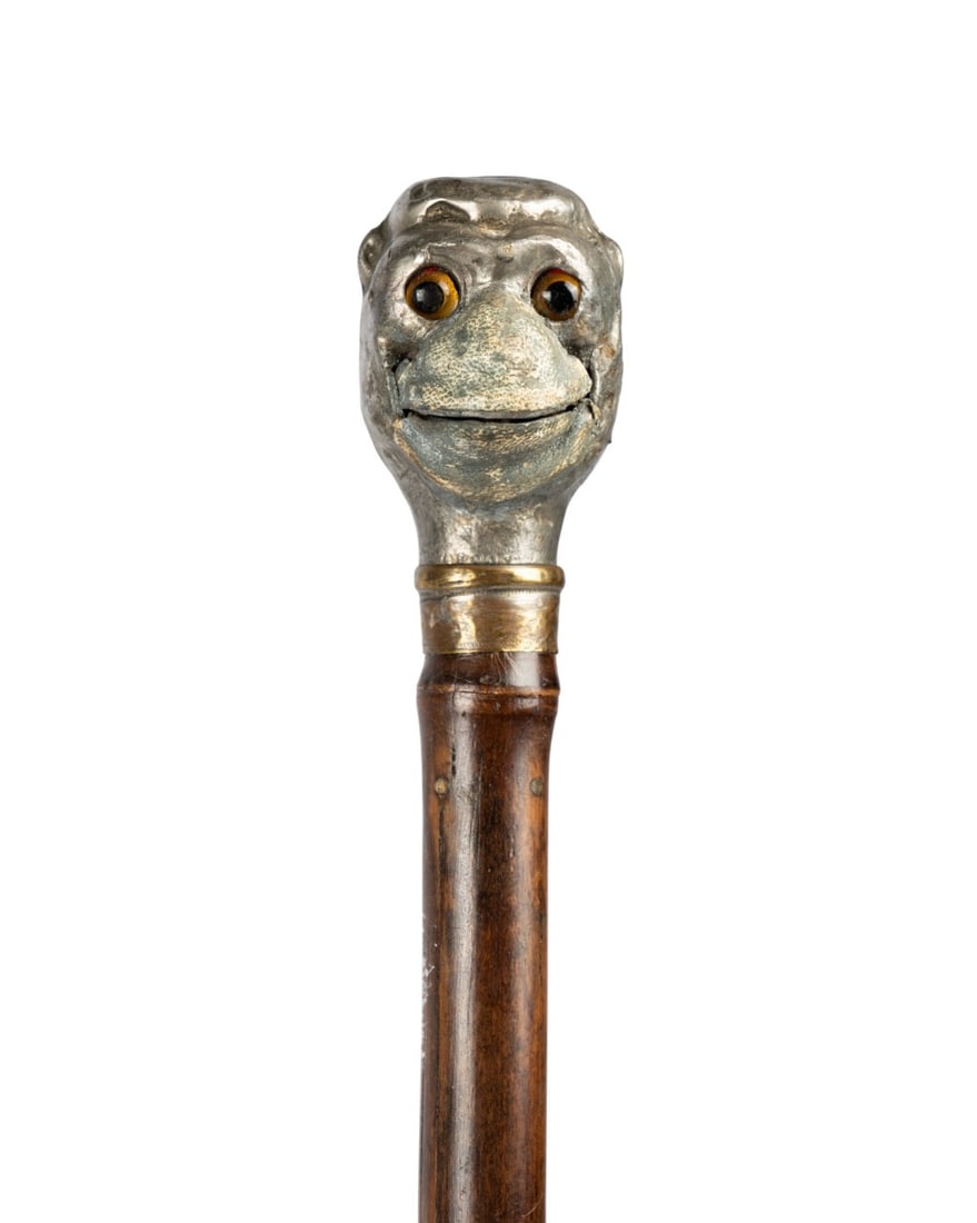 FRENCH PEWTER MONKEY AUTOMATA WALKING CANE: French, circa 1900. Walking cane with pewter monkey head handle with leather nose and mouth, lever activated automata mechanism opening the mouth, brass collar, brown bamboo shaft, and copper