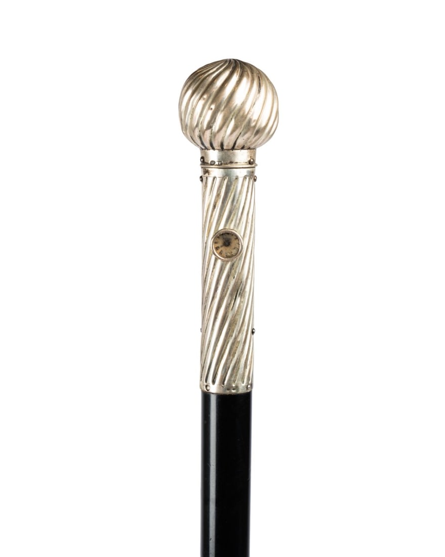 AUSTRIAN HOLUSKA SILVER WATCH CANE, C. 1885: Austrian, circa 1885. Holuska system watch walking cane with silver knob handle that winds watch on side of shaft and pull out knob to adjust time, long fluted spiral silver handle with ball top of