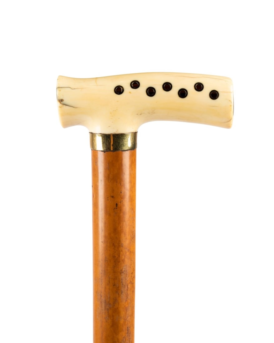 19TH C. ENGLISH HARMONICA MUSICAL CANE: English, circa 1880. Musical walking cane with carved bone handle incorporating round horn-rimmed holes for playing, supported by gold collar stamped "J.C.", with thick Malacca wood shaft terminating