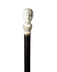 19TH C. GERMAN PORCELAIN PHRENOLOGY HEAD CANE: German, circa 1860. Walking cane with porcelain phrenology head handle, with a white crackle glaze, black lettering, and gold highlighting, gold wire collar leads to a shaft of Macassar ebony wood, an