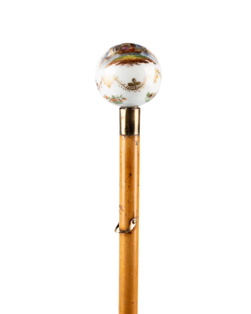 19TH C. RUSSIAN PORCELAIN LADIES WALKING CANE: Russian, circa 1850. Ladies' walking cane with porcelain ball handle painted with a river scene and gold filigree on the sides, supported by a brass collar with brass eyelet for a tassel, with shaft o