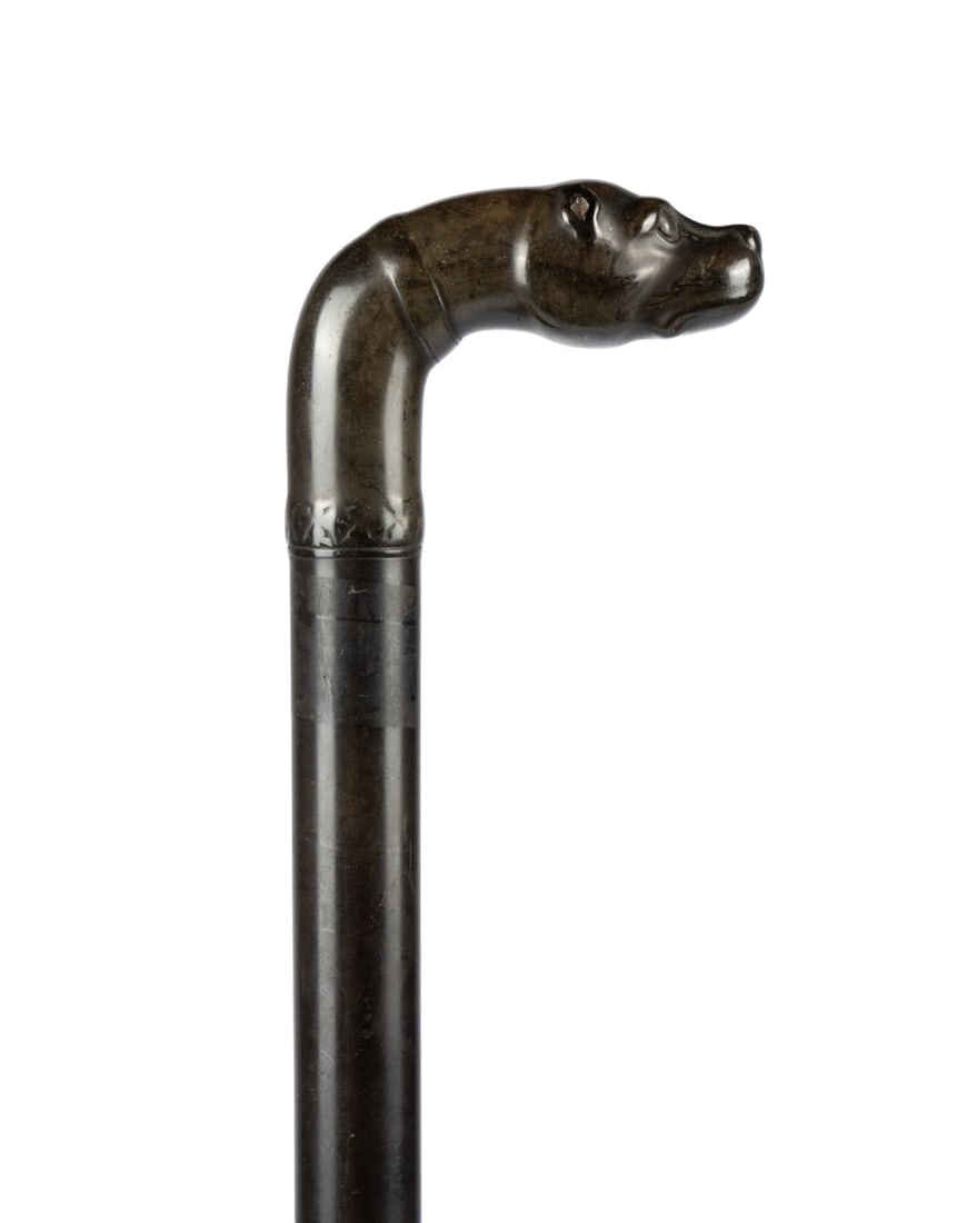 ENGLISH DOG HANDLE LADIES' WALKING CANE, C. 1900: English, circa 1900. Ladies' walking cane with petite L-shaped handle carved as a dog bust, handle and shaft of same material, and metal ferrule. Approximate measurements: length: 33.75"