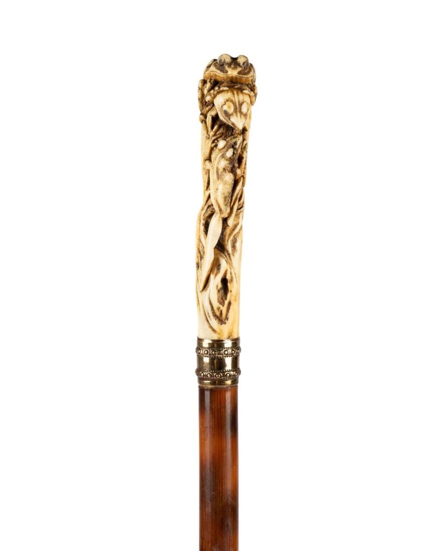 19TH C. JAPANESE STAG HORN FROG HANDLE CANE: Japanese, circa 1890. Walking cane with carved stag horn handle depicting three frogs on a log, gilt collar, smooth partridge wood shaft, and metal and iron ferrule. Approximate measurements: length: