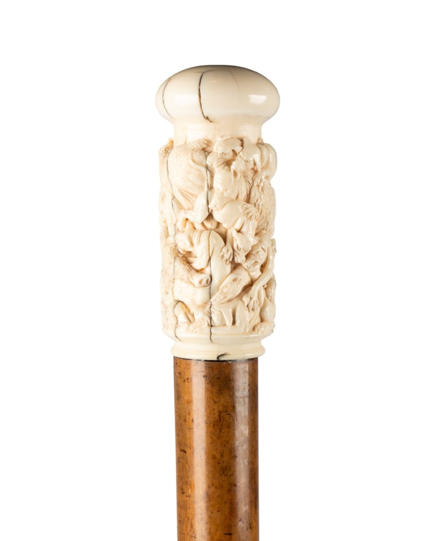18TH C. HIPPOPOTAMUS BONE CARVED HANDLE CANE: German, circa 1790. Walking cane with large turned hippopotamus bone knob handle carved with hunting scene of bear, stag, and wild boar with hounds, bright surface with aged patina and natural vertica