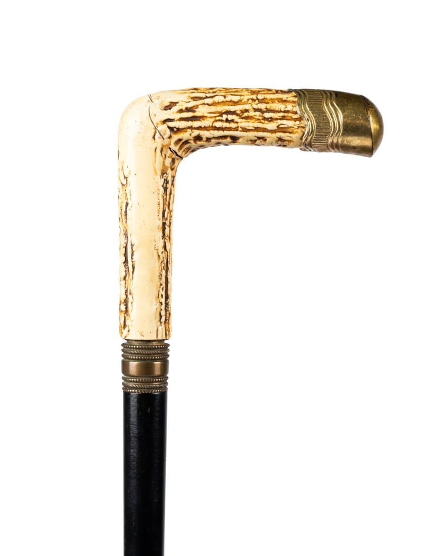 FRENCH SAINT ETIENNE PLUNGER TYPE GUN CANE: French, circa 1880, Saint Etienne (French, 1764-2001). Gun cane with an imitation stag horn handle typical of the period, brass collar, black-painted steel shaft serving as the gun barrel, removable s