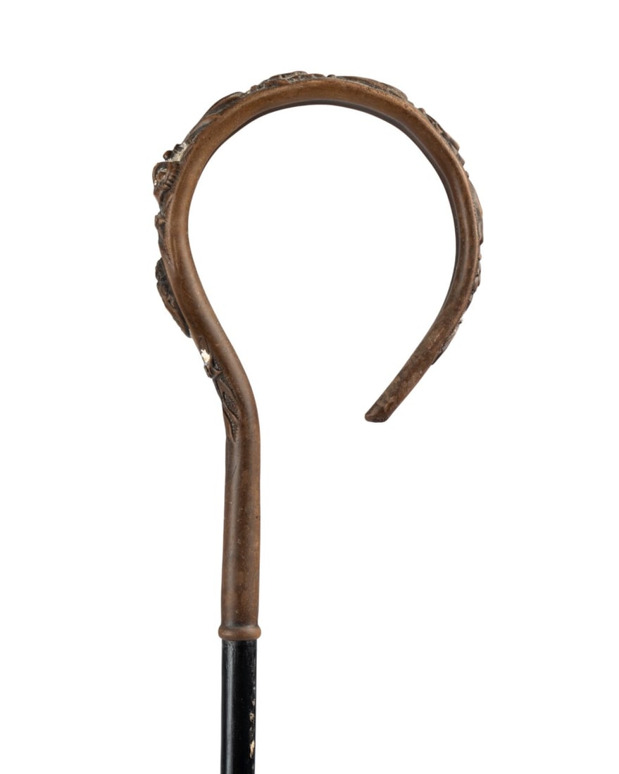 QUEEN VICTORIA GOLDEN JUBILEE COMMEMORATIVE CANE: English, 1887. Commemorative cane marking the Golden Jubilee of Queen Victoria with metal crook handle decorated with floral and leaf motifs, centered by a portrait of Queen Victoria between the years