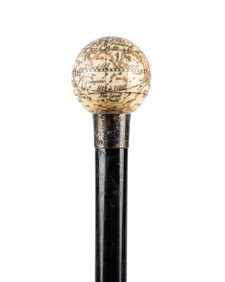 ENGLISH CARVED GLOBE HANDLE CANE, C. 1880: English, circa 1880. Walking cane with carved globe handle showing longitude, latitude, and continents, sterling silver collar, ebony shaft, and metal ferrule. Approximate measurements: length: 36.75"