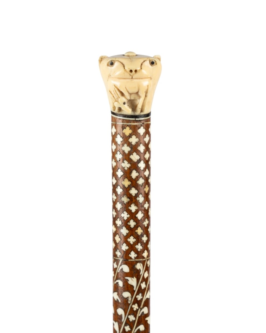 ANGLO-INDIAN INLAID WALKING CANE, C. 1910: Indian, circa 1910. Anglo-Indian walking cane with carved bone tiger head handle with small antelope in mouth, ebony separator, exotic hardwood shaft elaborately inlaid with hundreds of bone pieces