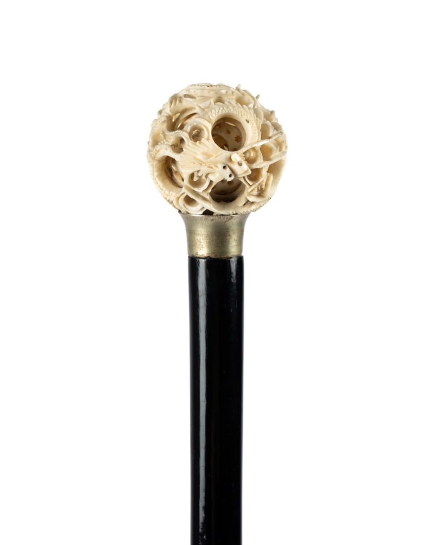 19TH C. CHINESE CONCENTRIC BALL WALKING CANE: Chinese, circa 1890. Walking cane with handle of carved concentric balls, exterior carved with dragons, silver-plated collar, dark Malacca shaft, and brass ferrule. Approximate measurements: handle:
