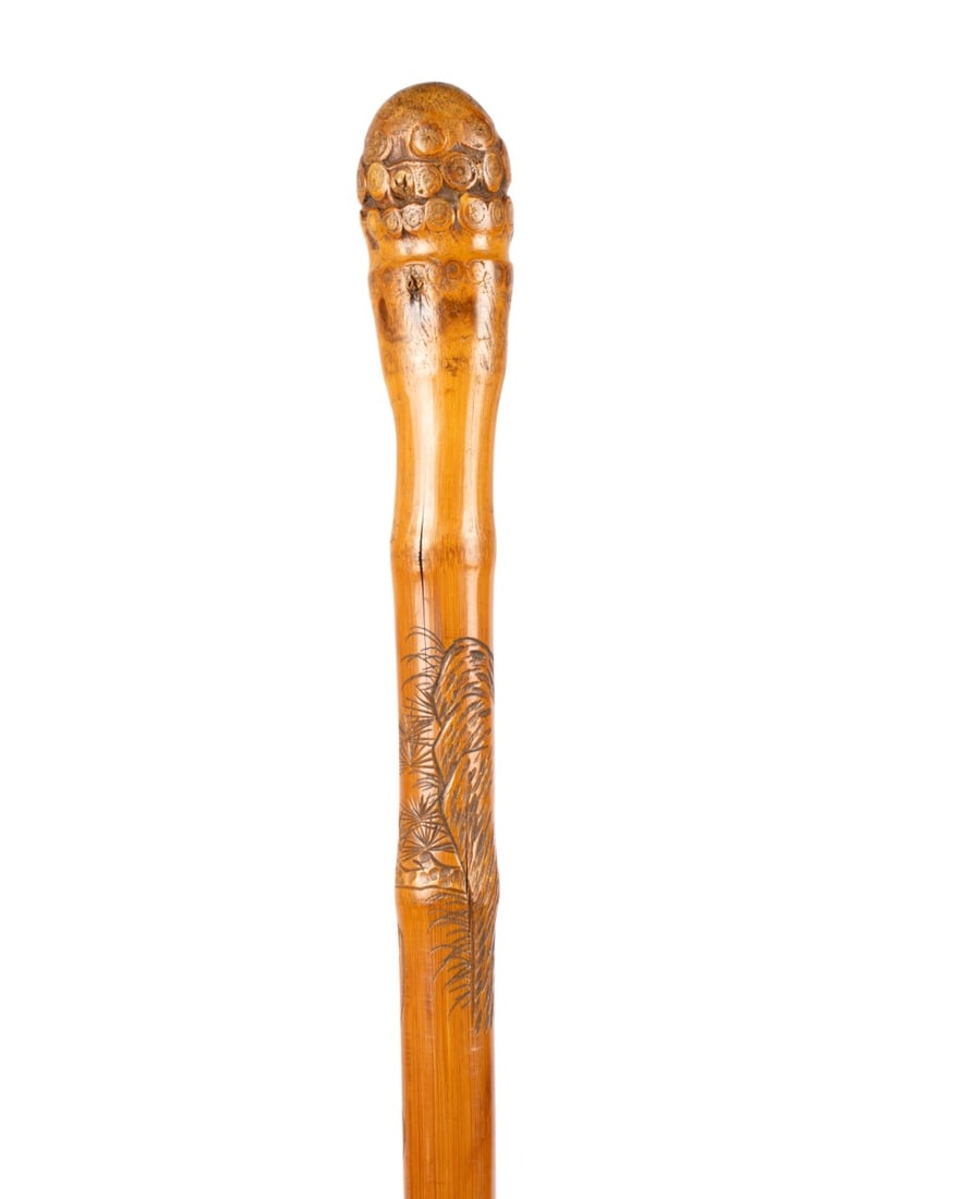 CHINESE CARVED FISHING ROD CANE, C. 1800: Chinese, circa 1800. Bamboo cane with gnarled joint handle, carved with two monkeys fishing and jumping fish, four Chinese characters beneath the carvings, shaft formed from the same piece of bamboo,
