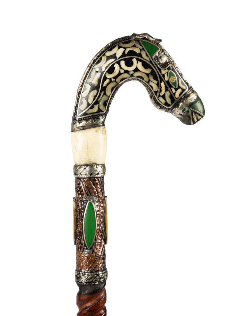 INDIAN INTRICATE HORSE WALKING CANE, C. 1870: Northern Indian, circa 1870. Walking cane with stylized horse head handle decorated with silver and inset stones, carved bone base, mixed metal collar with inset stones, medium stained spiral-turned