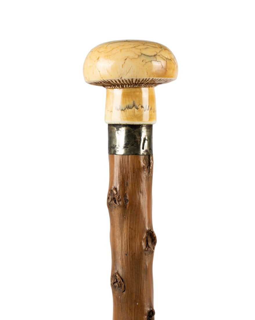 19TH C. MUSHROOM HANDLE WALKING CANE: Continental, circa 1880. Walking cane with carved mushroom handle, silver collar, natural tree limb shaft with uniform punched design and healed scars, and metal ferrule. Approximate measurements: han