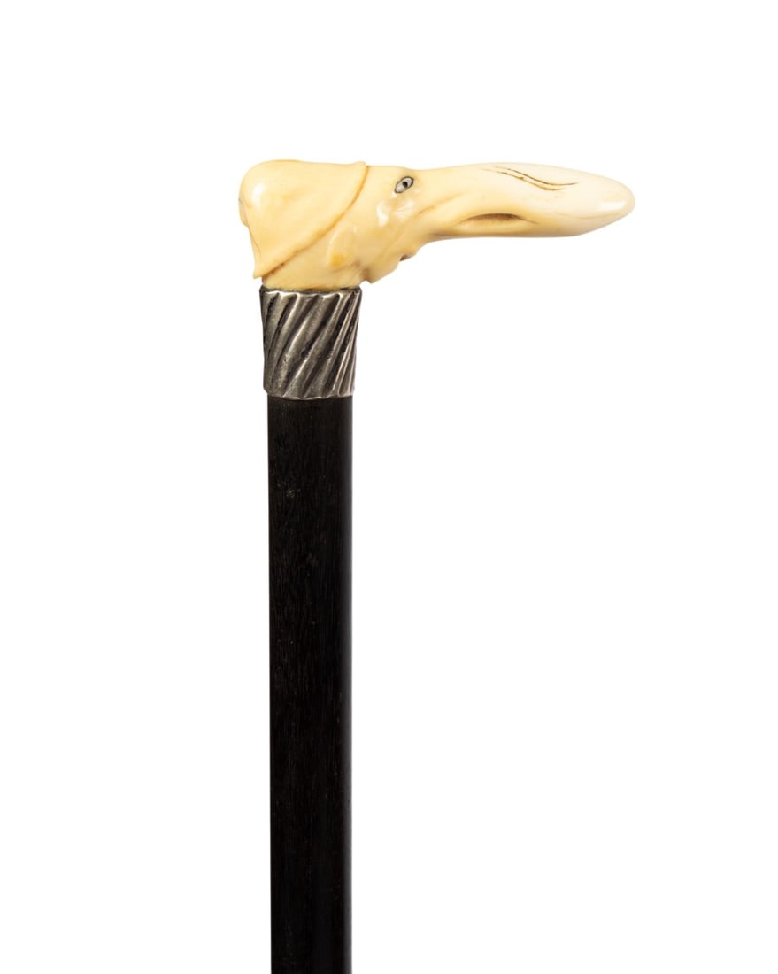 19TH C. ENGLISH DUNCE WALKING CANE: English, circa 1898. Walking cane with carved bone handle of long-nosed lad wearing dunce cap with mother of pearl eyes with black centers, silver collar with angled line decoration and Birmingham