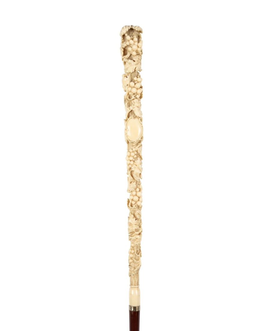 19TH C. GRAPES & VINES WALKING CANE: Continental, circa 1870. Walking cane with long carved bone handle decorated with grapes and vines and round unengraved cartouche, small silver collar, stained hardwood shaft, and brass and iron ferru