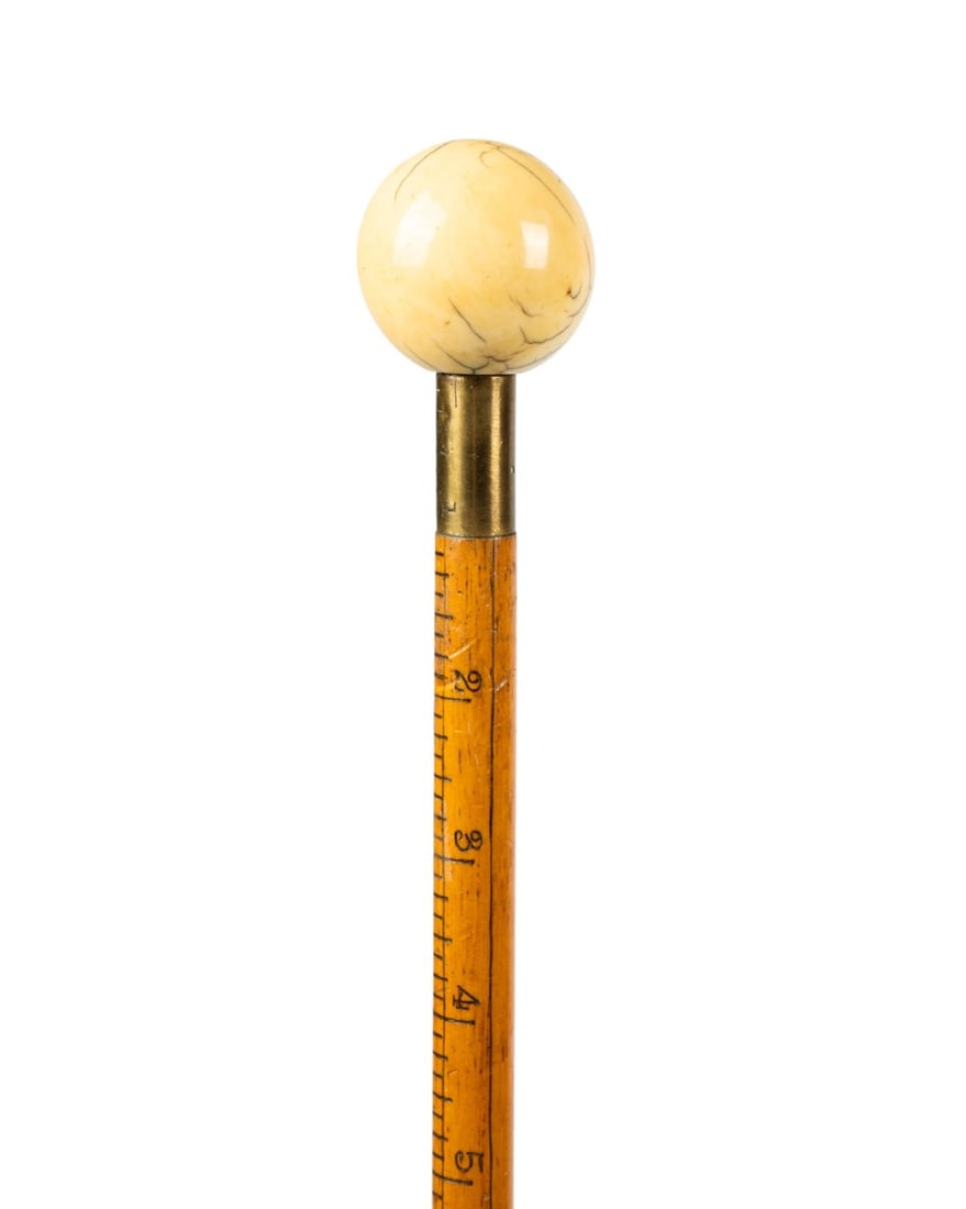 ENGLISH RABONE & SONS MEASURING CANE, C. 1870: English, circa 1870. Walking cane with carved bone sphere handle, brass collar, oak shaft with measuring lines, and metal ferrule marked "J. Rabone & Sons Birmingham Made in England". Approximate meas