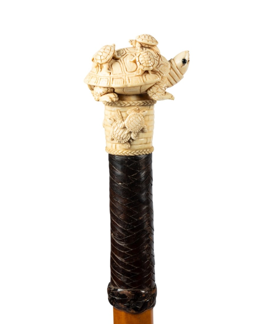 19TH C. ENGLISH TURTLE HANDLE WALKING CANE: English, circa 1870. Walking cane with carved bone handle of large turtle carrying five smaller turtles, carved bone collar with turtle and basket weave design, leather wrap, Malacca wood shaft, and h