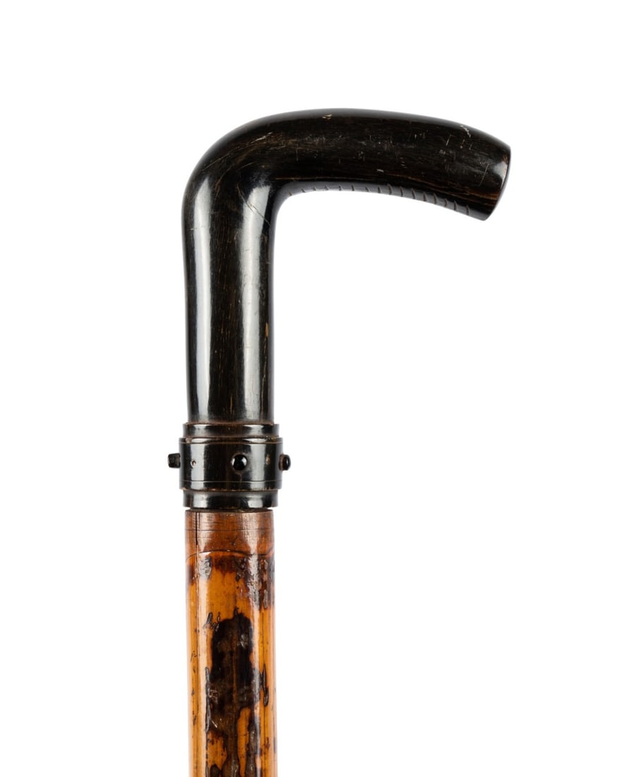 FRENCH TRI-EDGE DAGGER WEAPON CANE, C. 1910: French, circa 1910. Weapon cane with a horn-covered handle and collar, bamboo shaft terminating at a metal ferrule, the collar with a button that releases the handle to reveal a tri-edge dagger. Appro