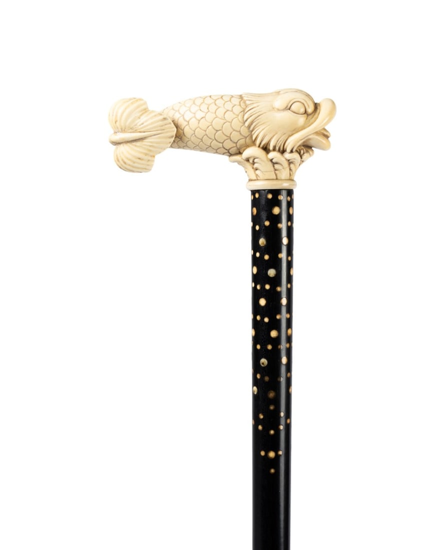 19TH C. FRENCH FISH HANDLE WALKING CANE: French, circa 1870. Walking cane with carved fish handle, tongue extended and tail curling back toward the body, on a highly decorated, twist-carved ebonized wood shaft with inset bone pieces, shaft
