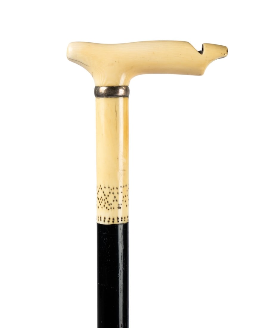 19TH C. ENGLISH WHISTLE WALKING CANE: English, circa 1850. Walking cane with carved whistle handle, whistle still operative, with large collar and additional carved decorative pieces matching the handle, ebony shaft, and horn ferrule. App