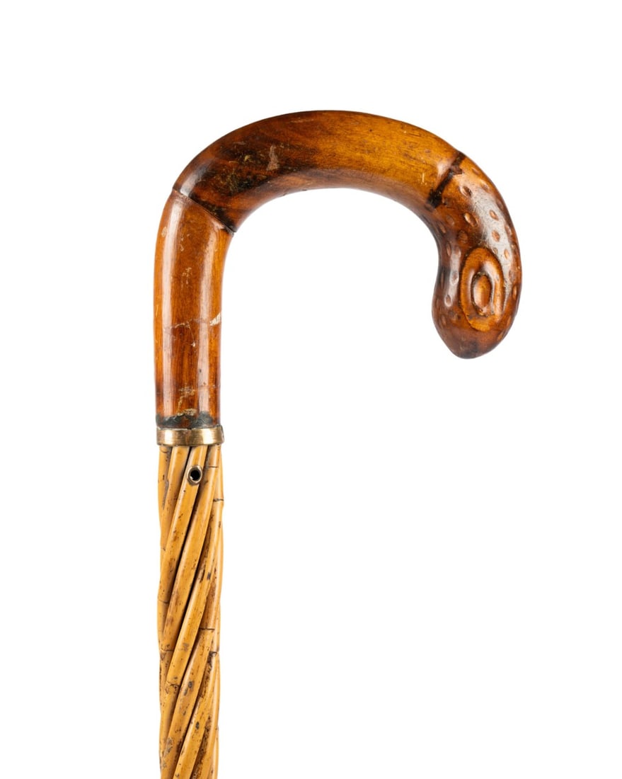19TH C. FRENCH STRAW WALKING CANE: French, circa 1880. Walking cane with lightly carved wooden crook handle, gilt collar, shaft formed from connected 35-inch sections of straw in spiral pattern with holes for cord handle below, and