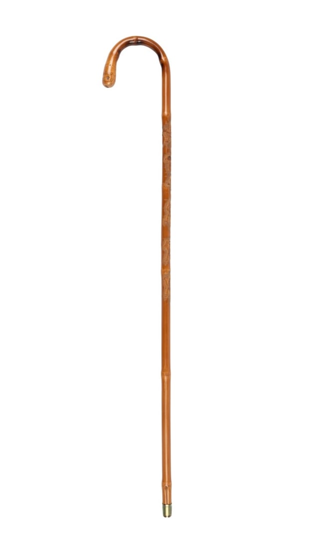 JAPANESE MEIJI SKELETON WALKING CANE, C. 1880: Japanese, circa 1880. Walking cane with bamboo crook handle with thick joint with shoots, shaft of continued bamboo carved with dancing skeletons with black eyes along two thirds of shaft, each figure