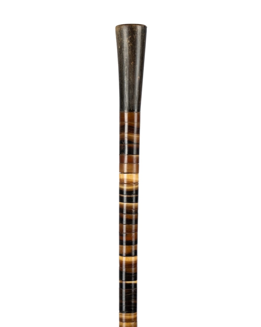 19TH C. ENGLISH COLORED HORN WALKING CANE: English, circa 1870. Walking cane made of colored horn sections on central iron support, with plain darker horn handle and ferrule. Approximate measurements: length: 34.75"