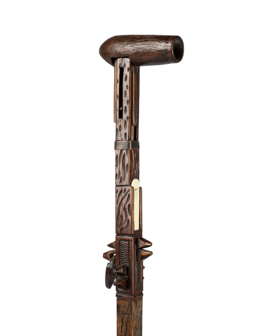 19TH C. ENGLISH FOLK ART WOOD CANE: English, circa 1860. Gadget cane with transforming handle hinging into pipe at right angles, compartment for matches with sliding cover below, additional section carved with free moving wooden padlock
