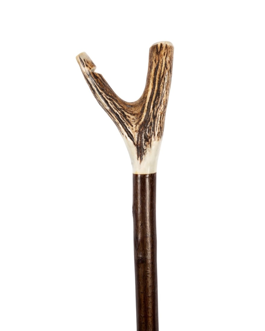 ENGLISH STAG HORN THUMB CANE WITH CARVED WHISTLE: English, circa 1930. Walking cane with V-shaped stag horn handle formed by two antler points, one point carved as a whistle, shaft of unknown wood limb, and a brass ferrule. Approximate measurements: