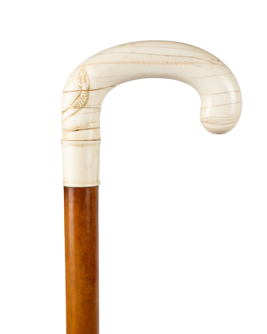 19TH C. ENGLISH SNAKE MOTIF WALKING CANE: English, circa 1890. Walking cane with hand-carved crooked handle with aged appearance, carved snake wrapped around short end of crook, full blond Malacca shaft, and white composite ferrule. Approxima
