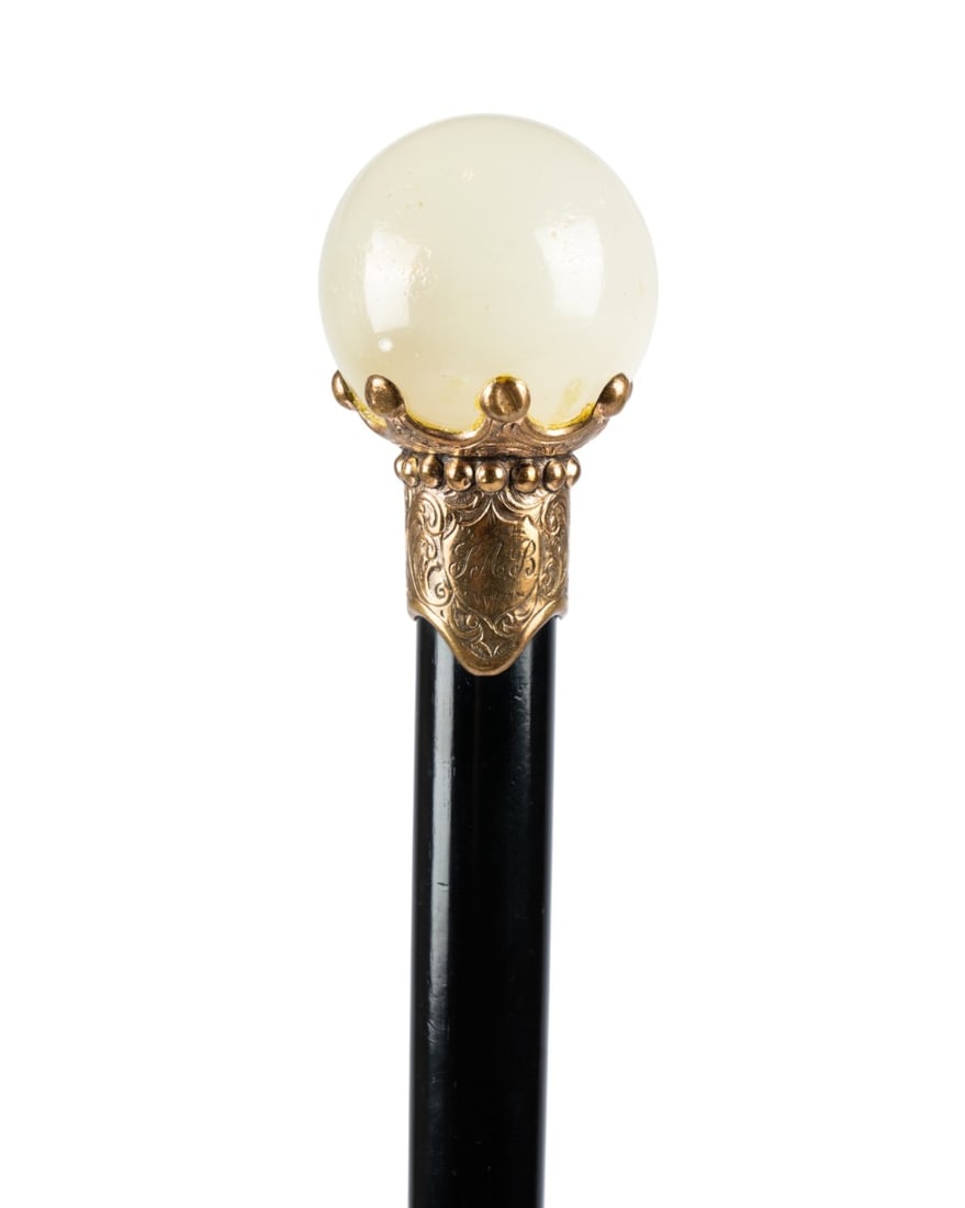 19TH C. ENGLISH WHITE AGATE WALKING CANE: English, circa 1890. Walking cane with milky white and gray agate sphere handle supported by a gold-filled collar with seven fingers cupping the sphere, decorated with C-scrolls and a cartouche
