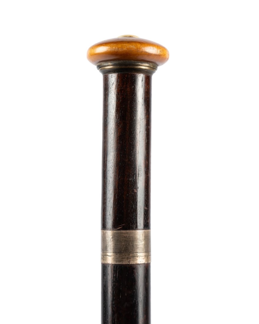 20TH C. ENGLISH WALKING CANE W/ DOCUMENT IN HANDLE: English, 1920s. Walking cane with a flat wooden knob handle supported by a silver collar; dark-stained, tapered shaft with horn ferrule. The top unscrews to reveal a freedom document issued to Edmund