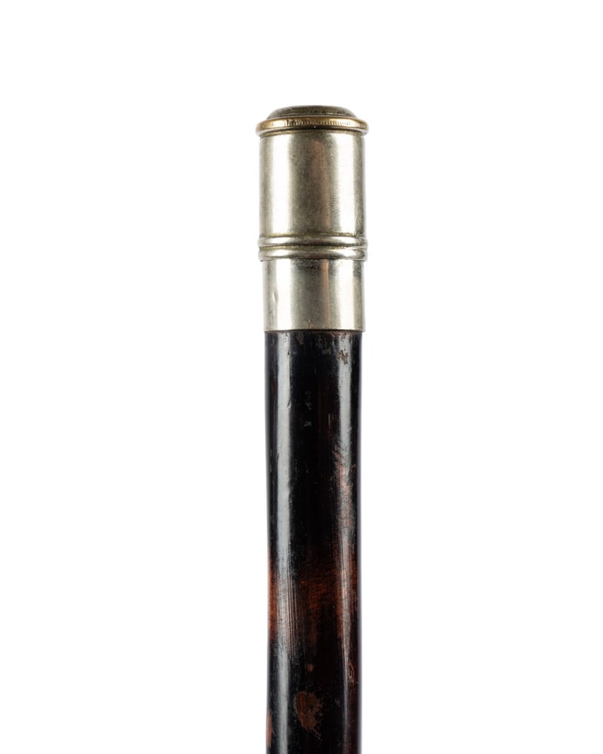 ENGLISH STORAGE GADGET CANE, C. 1910: English, circa 1910. Walking cane with a silver knob handle on a silver collar, with an exotic hardwood shaft terminating at a metal ferrule, with the knob pulling out to reveal a metal tray for