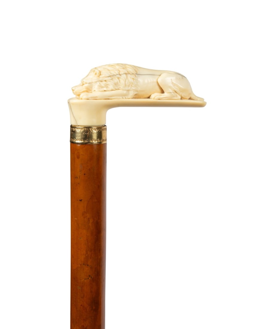 19TH C. AMERICAN RECLINING LION WALKING CANE: American, circa 1858. Cane with an L-shaped handle depicting a carved bone male lion in a stalking pose, engraved 18k gold collar inscribed "Geo. C. Robinson, From His Brother, New York 1858," thick,