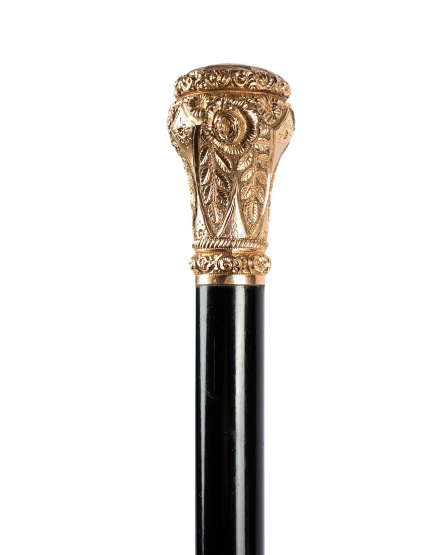 19TH C. ENGLISH GILT TOP PRESENTATION CANE: English, circa 1890. Walking cane with ornate gilt top with botanical decorations in relief and engraved, engraved at the top "Presented to M. Nolan by Employees of BCD Wrks, December 17, 1890," with