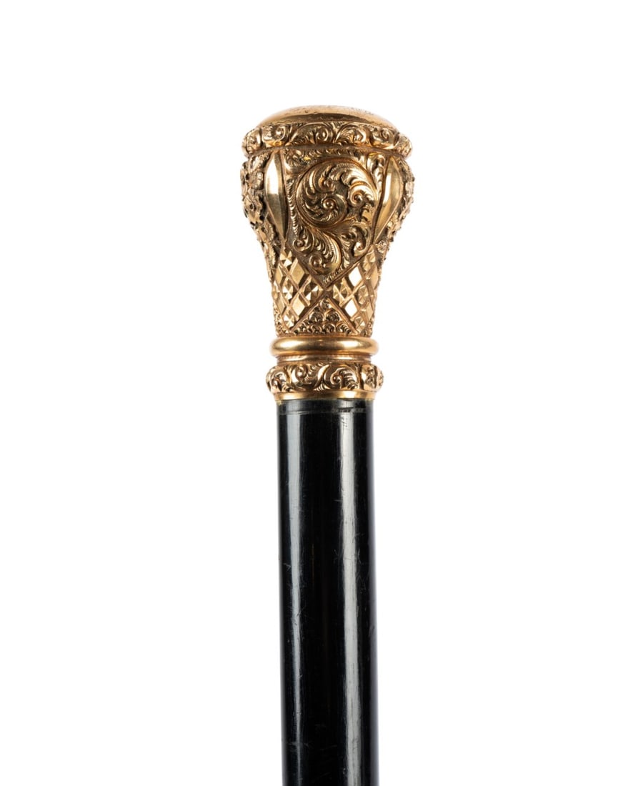 AMERICAN GILT HANDLED PRESENTATION CANE, 1897: American, circa 1897. Walking cane with ornate gilt handle with scrolls, florals, and repeating patterns, engraved at the top "Presented to N. Harris by the Students of Baylor University Oct. 5, 1897,